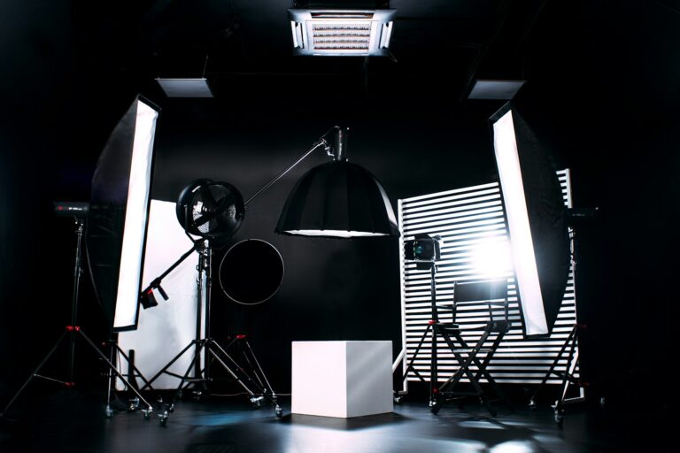 Professionele fotostudio ingericht met softboxen, een grote paraplu-diffuser en een witte kubus als podium, strak en high-contrast verlicht.